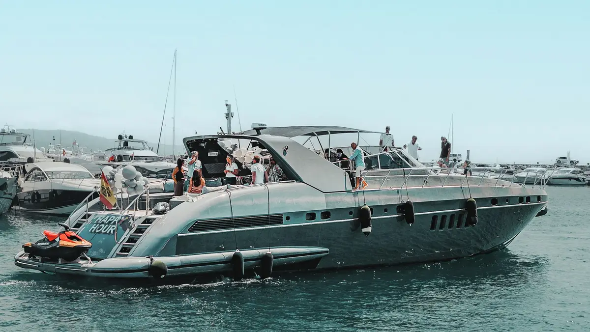 Mangusta 80 Happy Hour with guests on deck and a jet ski at the stern