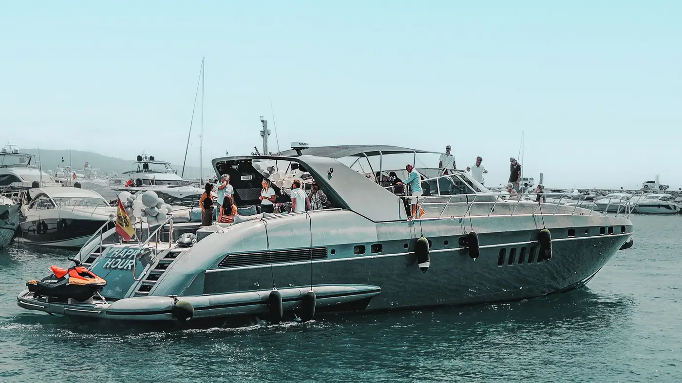 Mangusta 80 Happy Hour with guests on deck and a jet ski at the stern