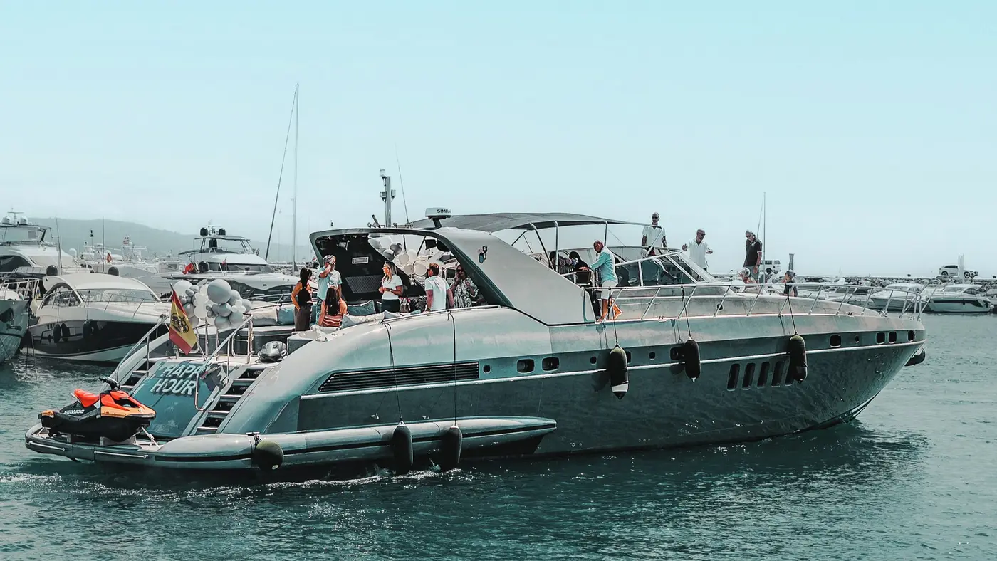 Mangusta 80 Happy Hour with guests on deck and a jet ski at the stern