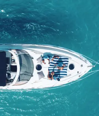 Aerial view of guests on the bow sun pad of BLTN