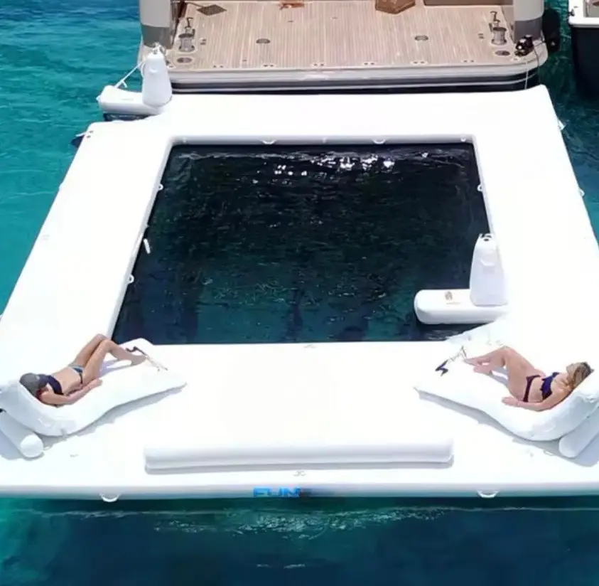 Guests sunbathing beside the floating pool at anchor