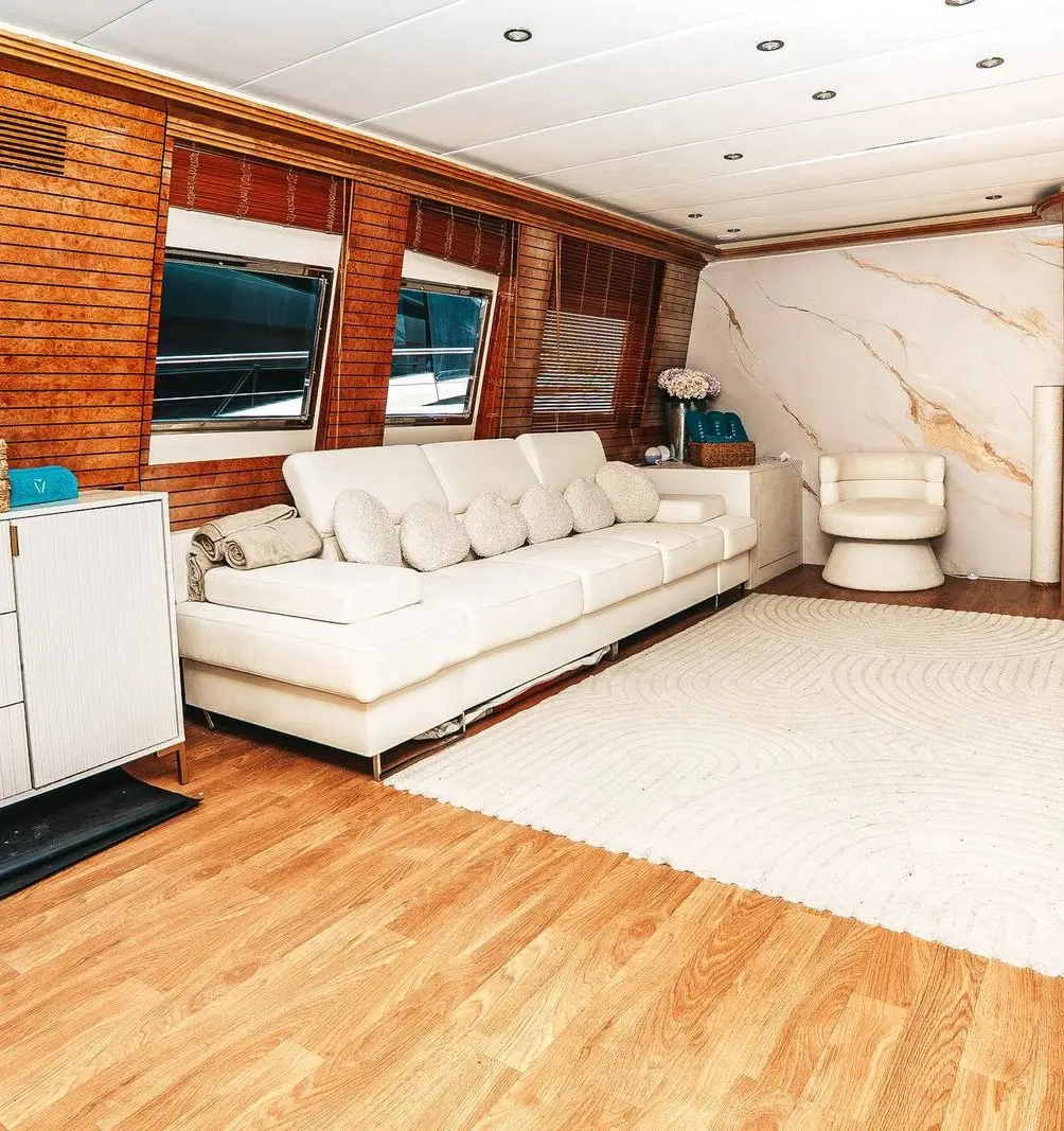 Main salon with white sofa, wood panelling and marble-effect wall