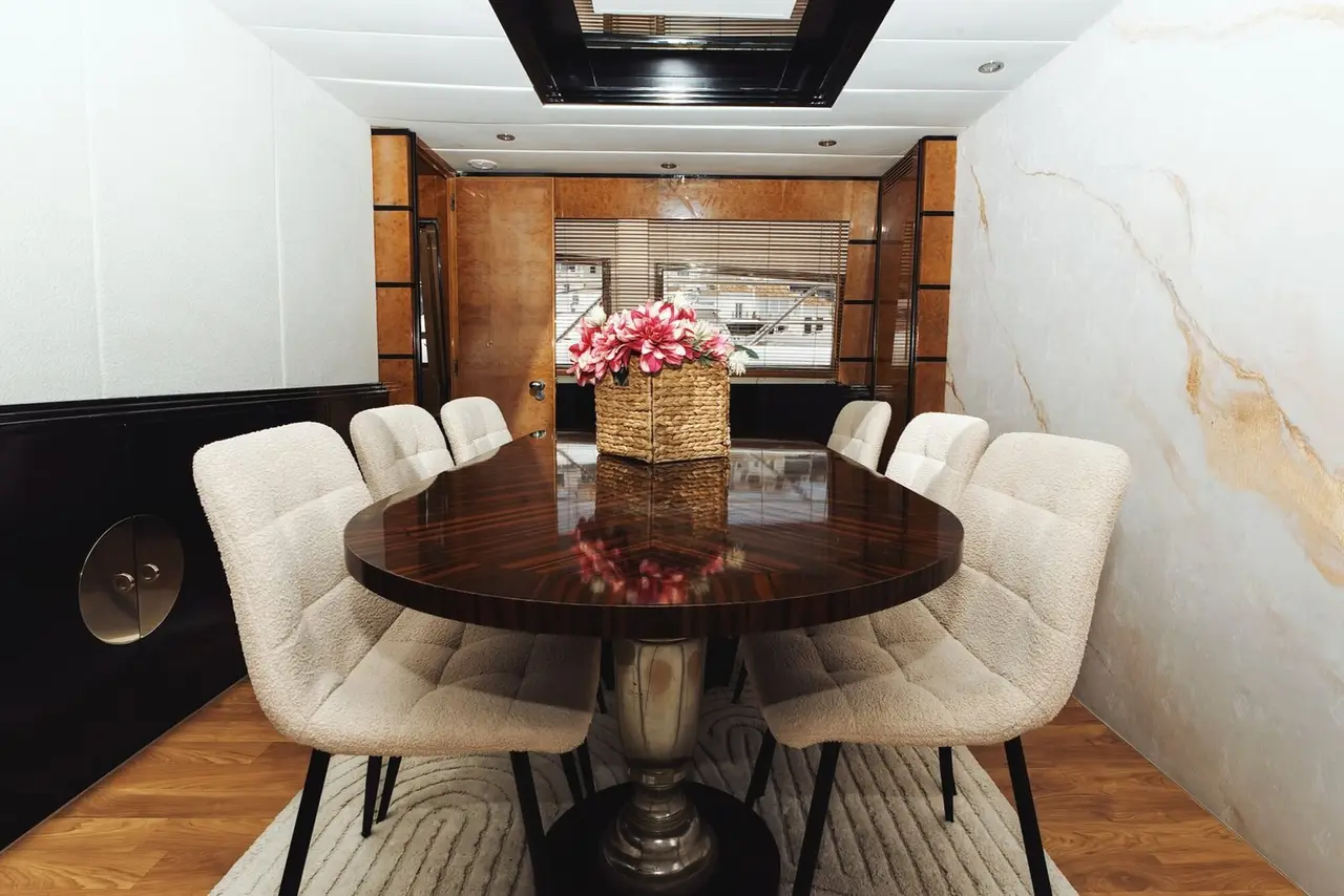 Dining area with dark oval table, cream chairs and flowers