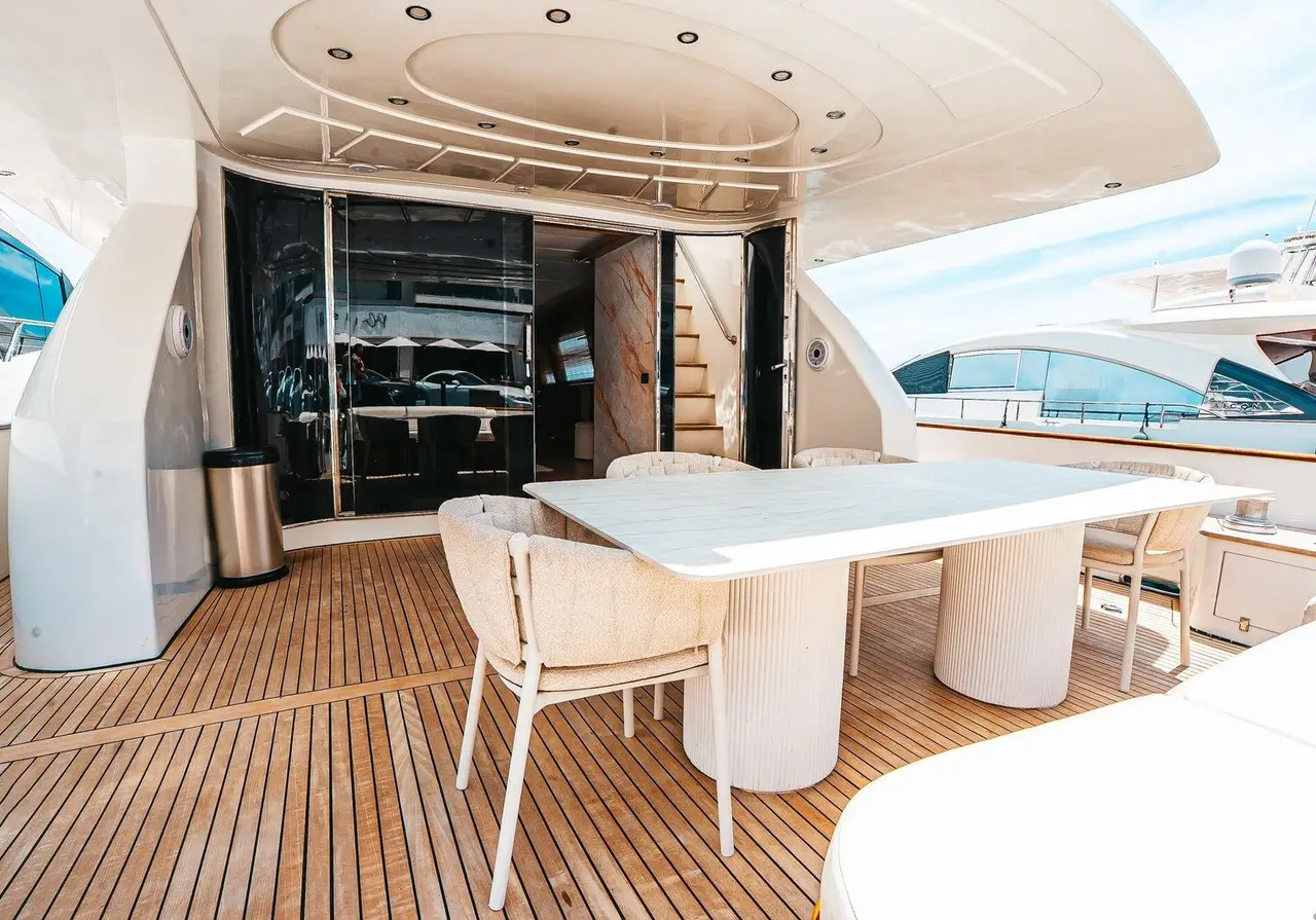 Shaded aft deck with teak floor and a white dining table