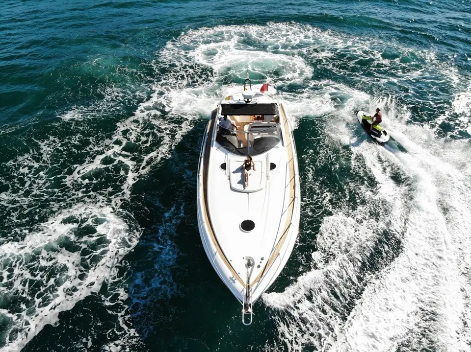Aerial view of Vibe with a jet ski circling astern