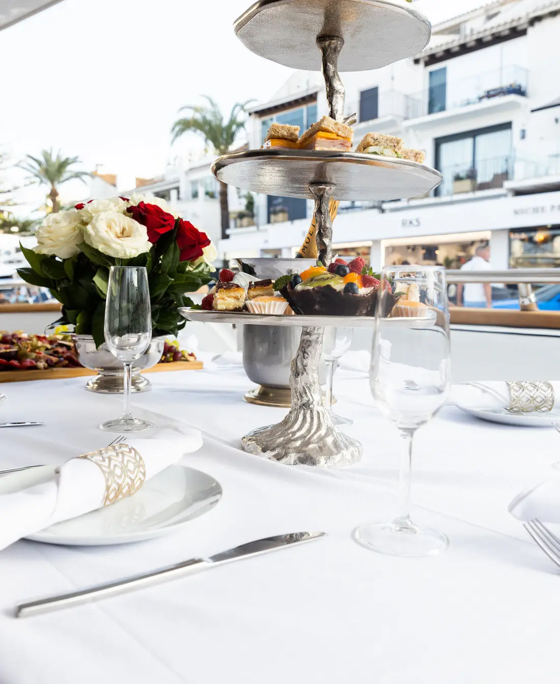 Table set with a cake stand and roses in Puerto Banús