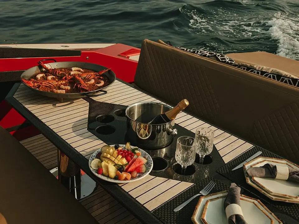 Paella, fruit and champagne on the deck table of Andalusi